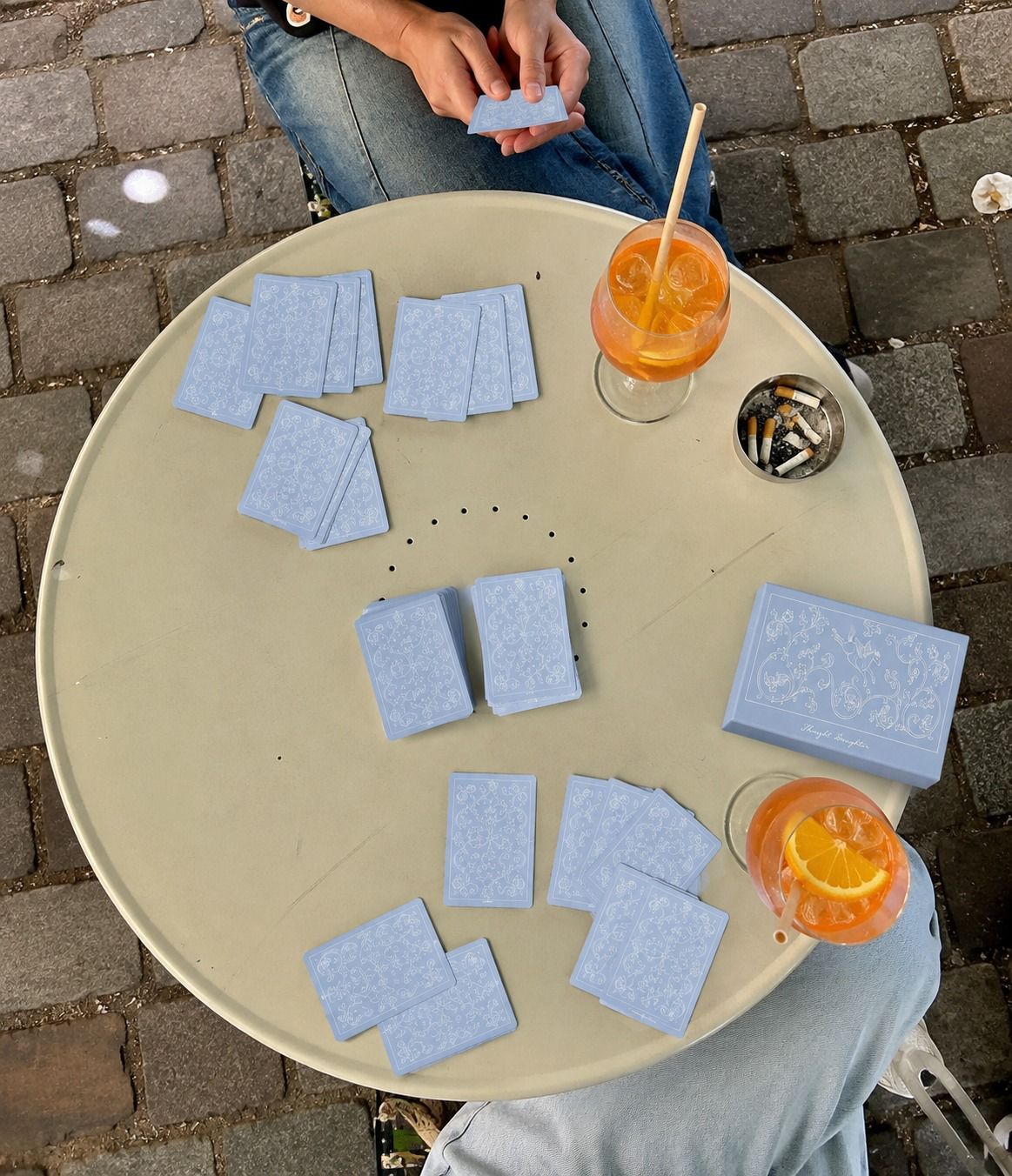 Thought Daughter cards scattered across a café table
